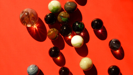 Light Reflecting on Glass Marbles on a Red Surface | Colored Glass Marbles
