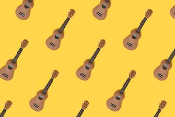 Ukulele pattern on a bright yellow background. Hawaiian guitar creative concept.