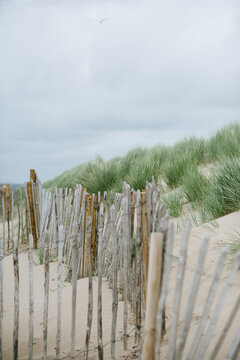 Weathered wooden fence and sand dunes at the beach