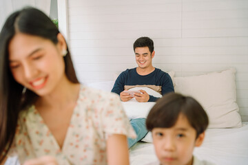 Obraz premium Father enjoy watcing movine with smartphone on a bed.