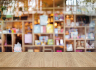 Wooden board empty table top counter of blurred shelf on background. Perspective brown wood table over blur in modern shop background for mock up.