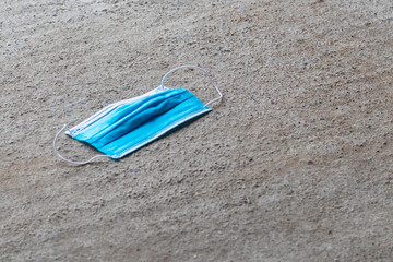 Big city. A medical disposable mask lies on the concrete floor. Close-up