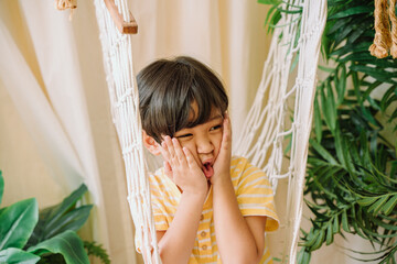 Cheerful asian thai boy on hammock.