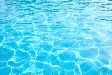 Blue pool water with sun reflections. Texture for background