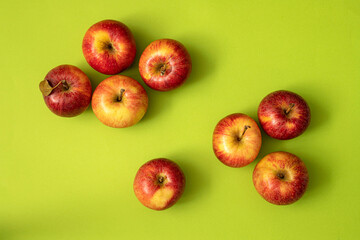 Fresh, ripe apples on a green background.Top view