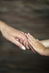 Daughter and mother holding hands, close up