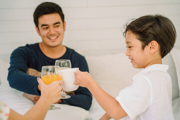 Asian thai family toast glasses with healthy beverage.