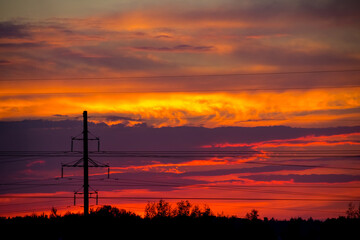 fiery sunset on the background of power lines
