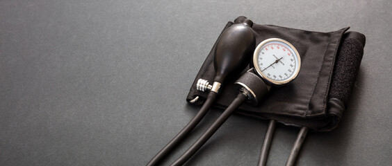 Medical sphygmomanometer on black background, closeup view.