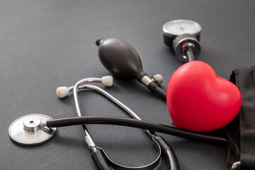 Medical stethoscope and sphygmomanometer on black background, closeup view.