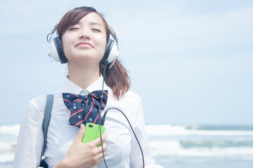 ヘッドホンで音楽を聴く女子高校生