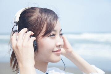 ヘッドホンで音楽を聴く女子高校生