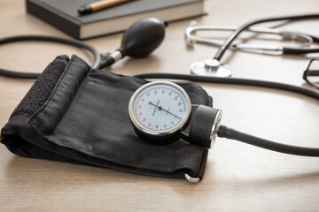 Medical stethoscope and sphygmomanometer on wooden background