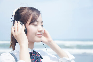 ヘッドホンで音楽を聴く女子高校生