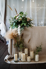 flowers and candles in the decoration of the wedding table, wedding decor, tablecloth made of natural materials, table setting.