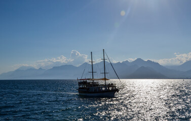 Fototapeta premium Pleasure tourist yacht in the Mediterranean Sea on the back of high beautiful mountains near coast Antalya