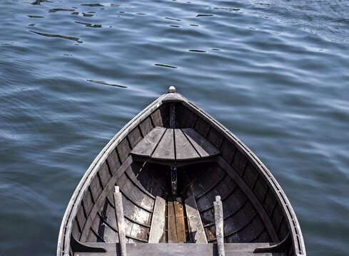 Empty Wooden Rowboat Floating In Calm Waters
