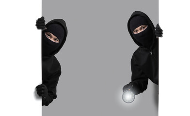 Burglar concept,Masked thief in balaclava with flashlight on gray background