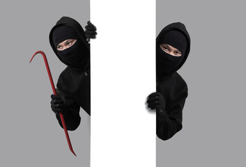 Burglar concept,Masked thief in balaclava with crowbar on gray background