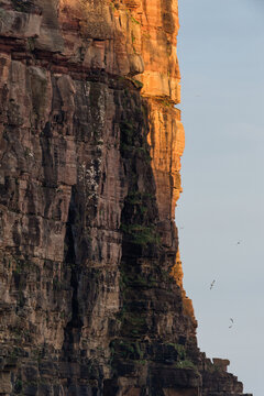 sun about to set on the cliffs of hoy island, orkney, scotland