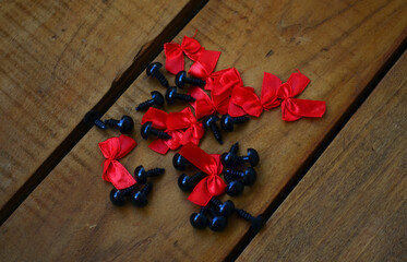 Red bows and plastic eyes for knitted toys. Needlework.