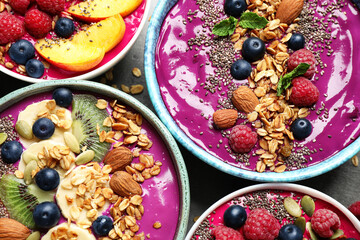 Delicious acai smoothie with toppings in bowls on table, flat lay