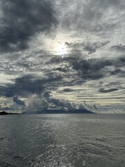 Fototapeta na wymiar Soleil à travers les nuages sur la mer à Tahiti, Polynésie française