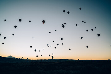 Flying silhouettes of air balloons in valley