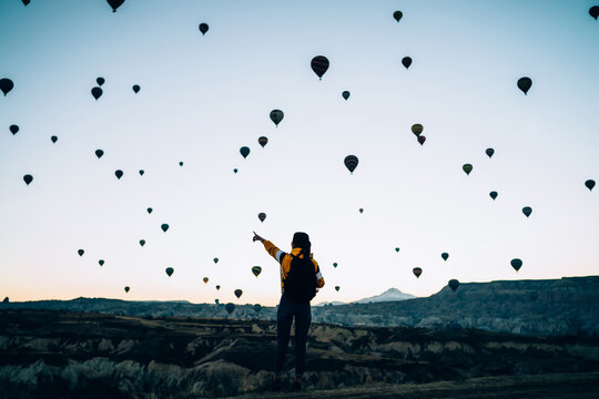 Female in rocky terrain with air balloons