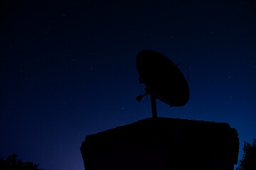 Antena con el cielo de noche de fondo. Tonos azulados y estrellas