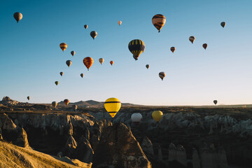 Colorful air balloons racing over rocky terrain