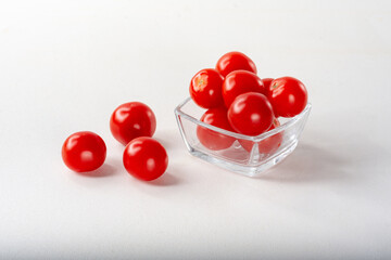 Cherry tomatoes in a glass bowl. Ripe cherry tomatoes on a light background for insulation.