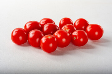 Cherry tomatoes on a light background. Ripe cherry tomatoes on a white background for insulation.