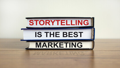 Books with text 'storytelling is the best marketing' on beautiful wooden table, white background. Business concept. Copy space.