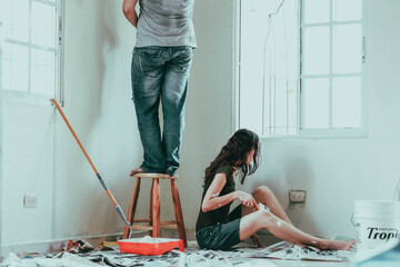 Pareja recién casada recibiendo y pintando su nuevo hogar.