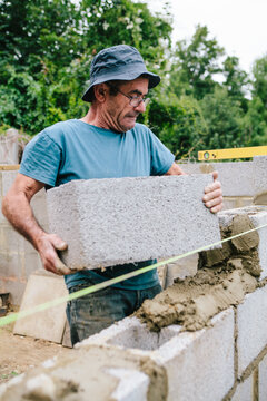 Builder working on a construction site building a wall