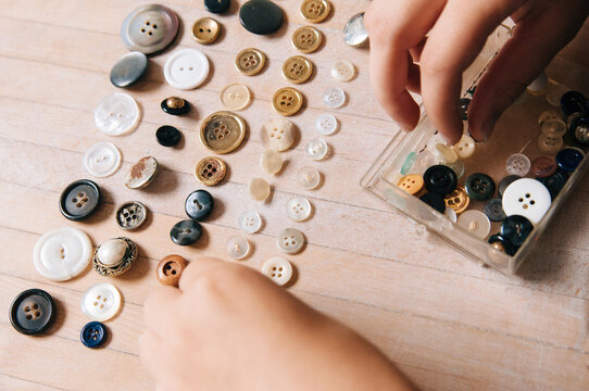 hands sorting vintage buttons