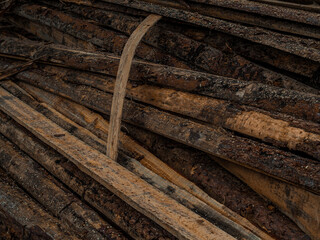 Sticks, boards, wooden logs wooden with knots and sawdust on the sawmill industrial sawing of trees. Background, texture.