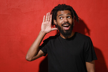 Excited curious young african american man guy with dreadlocks 20s in black t-shirt posing try to...