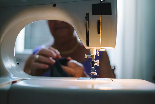 Senior woman is sewing at home