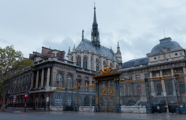 Obraz premium The front entrance of the Palais de Justice and Saint Chapel chapel in Paris, France in rainy summer evening.
