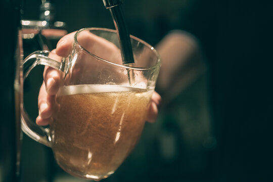 Barman Spilling A Draft Beer. Close Up