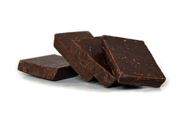 Chocolate cubes, dark bitter chocolate bar pieces isolated on white background, close-up view.