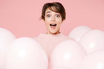 Obraz na płótnie Canvas Shocked young brunette woman girl in knitted casual sweater posing isolated on pastel pink background studio portrait. Birthday holiday party, people emotions concept. Celebrating hold air balloons.