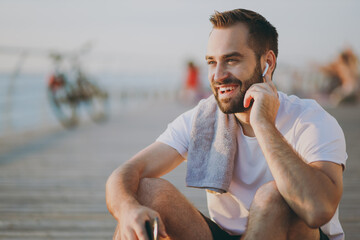 Portrait of young handsome smiling bearded fitness athletic man guy 20s in casual white t-shirt...