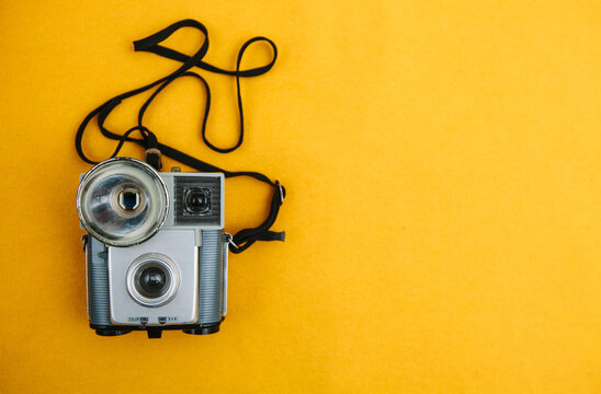 Vintage camera on a yellow background.