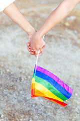 Hands of two women with pride flag
