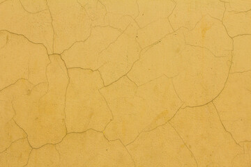 Close up the cracked light yellow concrete wall background