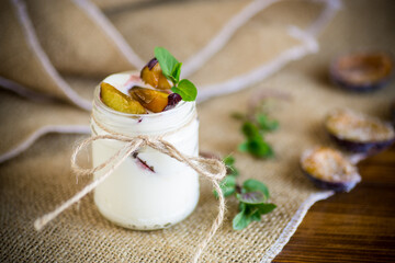 Homemade sweet yogurt with slices of ripe plums in a glass
