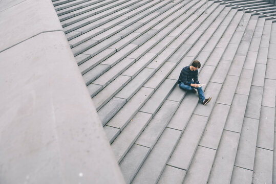 Man reading book on stairway
